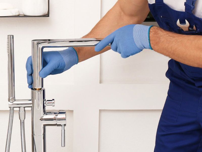 Plumber fixing tap in bathroom John G. Plumbing Drain and Sewer Cleaning